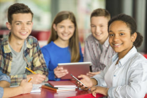 four teenagers sitting at a table